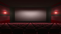 an empty cinema with red seats and a screen