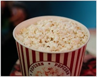 a bucket of popcorn sitting on top of a table